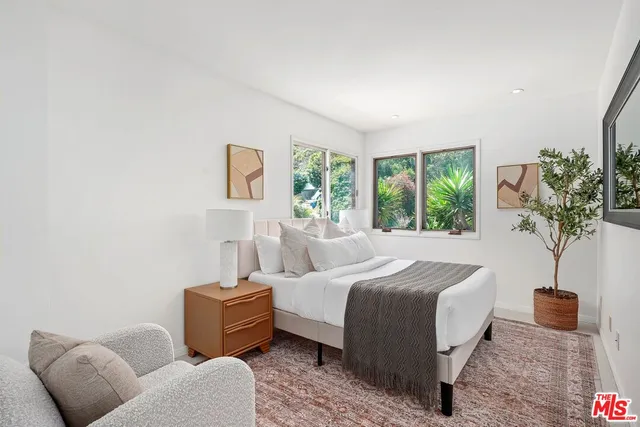 a bedroom with bed and a potted plant