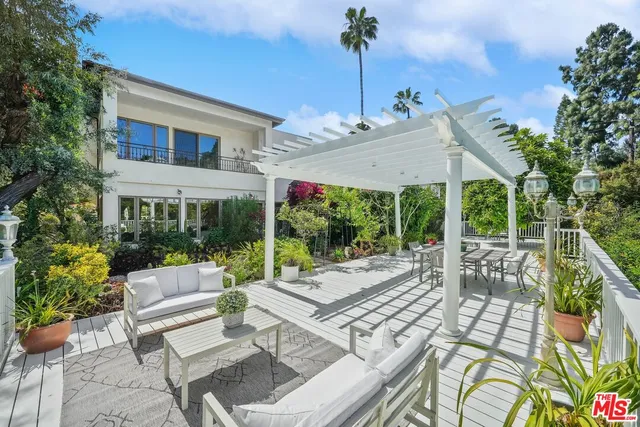 a view of a patio with couches table and chairs and potted plants
