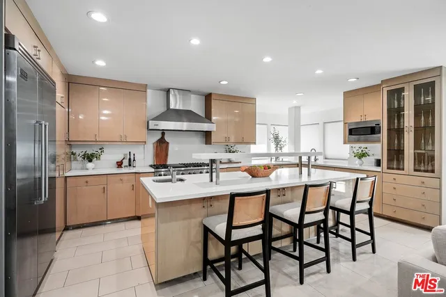 a kitchen with stainless steel appliances granite countertop a table chairs sink refrigerator and cabinets