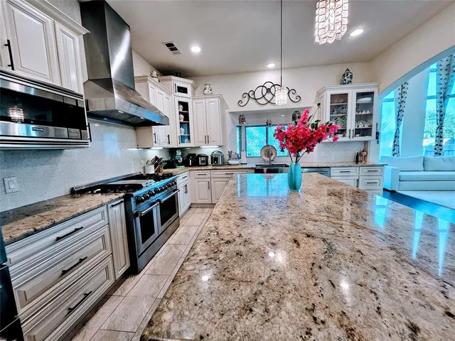 a kitchen with granite countertop a stove a sink and dishwasher wooden cabinets with granite countertops