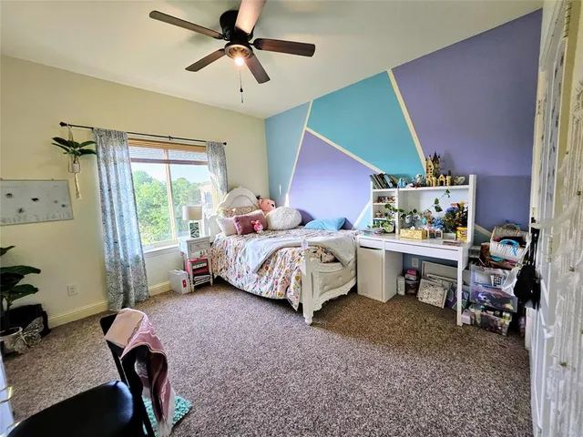 a bedroom with a bed a couch and a window