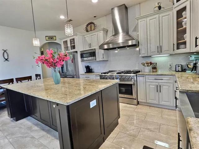 a kitchen with stainless steel appliances granite countertop a sink a stove and a refrigerator
