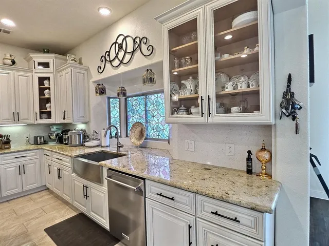a kitchen with stainless steel appliances granite countertop a sink and cabinets