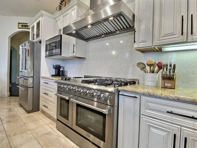 a kitchen with stainless steel appliances granite countertop a stove and a refrigerator