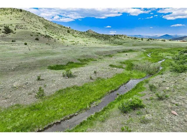 a view of a lush green hillside and an houses