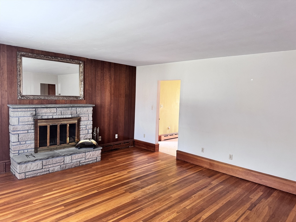 77 Grattan Street Fall River, MA 02721 - Photo 7 of 20 a view of a livingroom with wooden floor and a fireplace