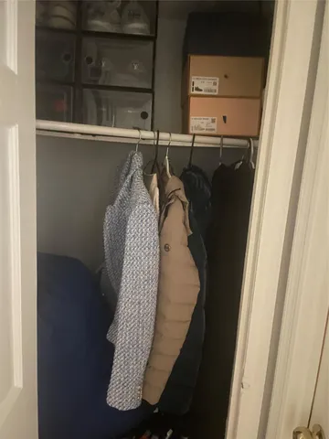 a view of walk in closet with clothes and shoes