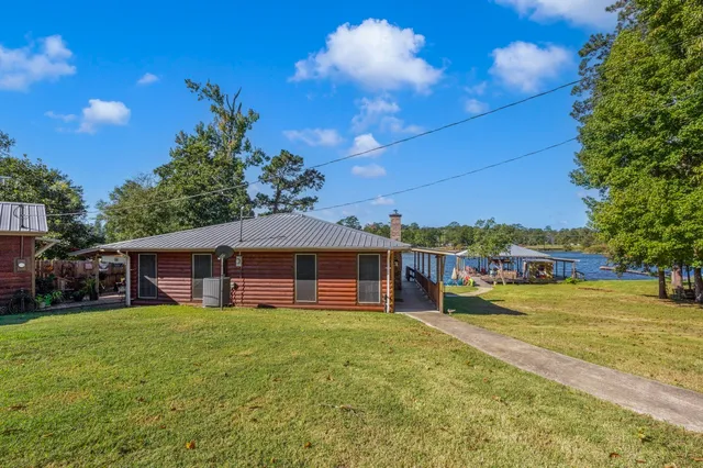 a view of a patio with table and chairs potted plants and large tree