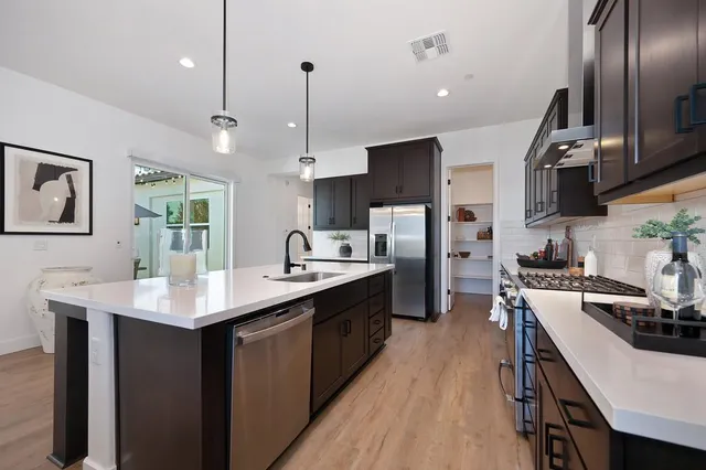 a kitchen with stainless steel appliances kitchen island a sink stove and refrigerator