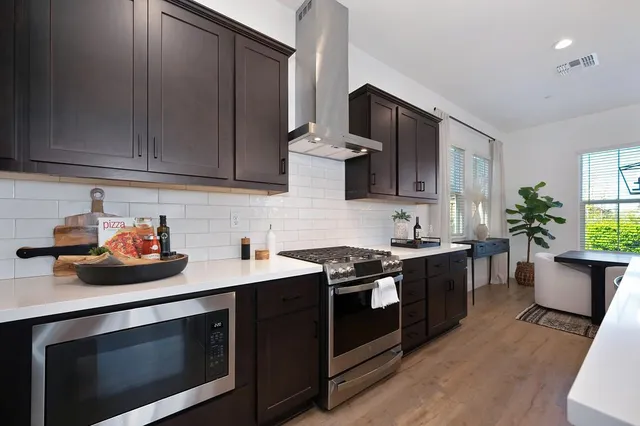 a kitchen with stainless steel appliances a sink stove and cabinets