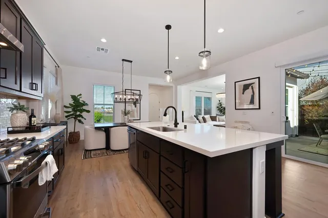 a kitchen with sink a stove and wooden floor