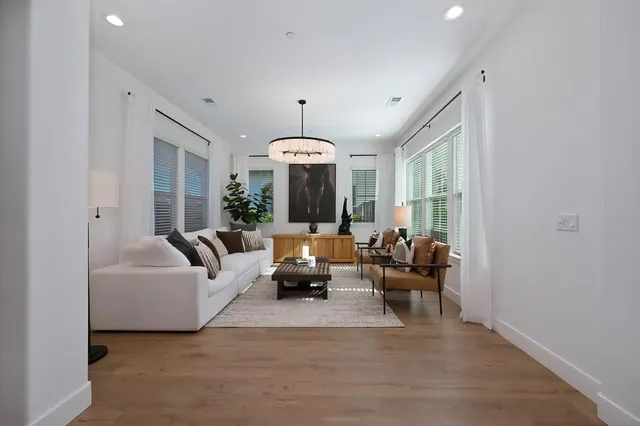 a living room with furniture potted plant and a chandelier