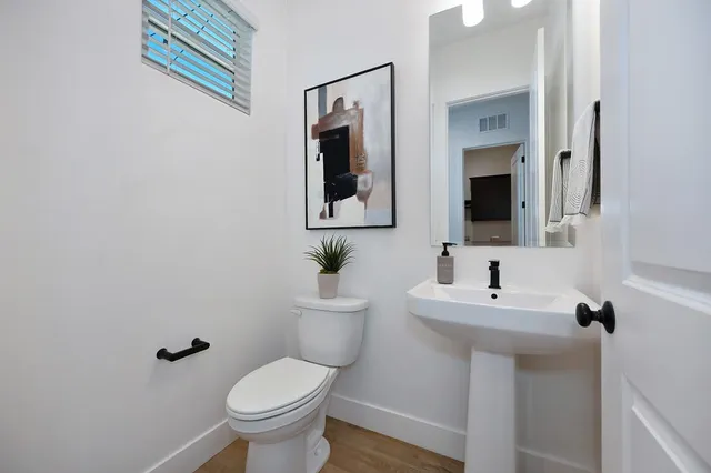 a bedroom with a bed a mirror on dresser and a chandelier