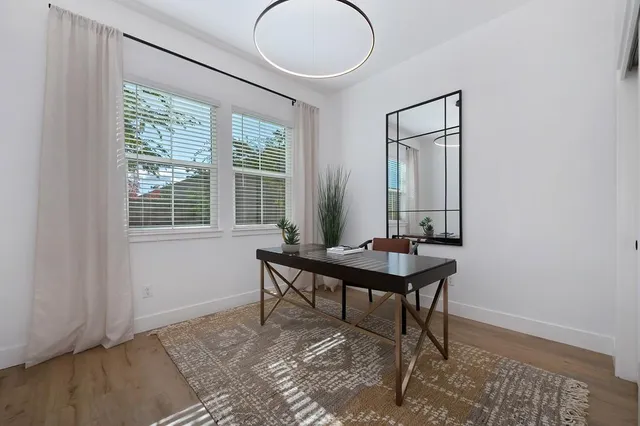 a view of a hallway with wooden floor and staircase