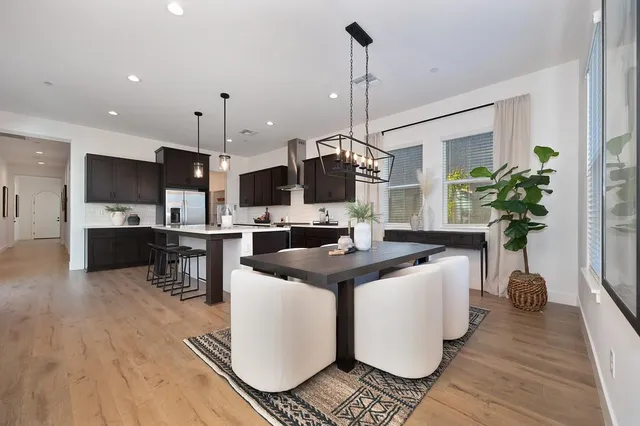 a kitchen with stainless steel appliances kitchen island granite countertop a sink a stove and a wooden floors