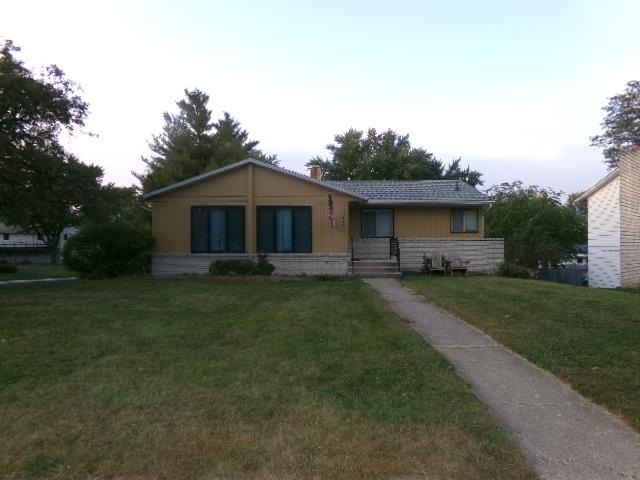 a front view of a house with a yard and trees