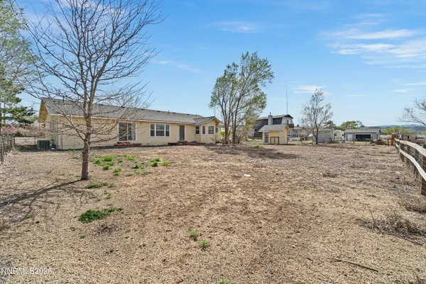 a view of house with yard and trees in the background