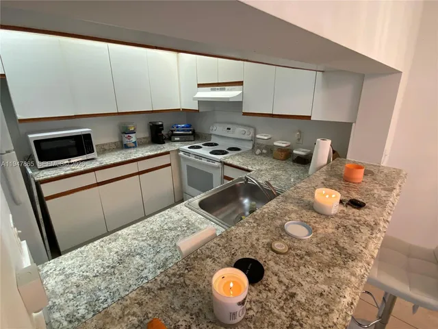 a kitchen with a sink a stove and cabinets
