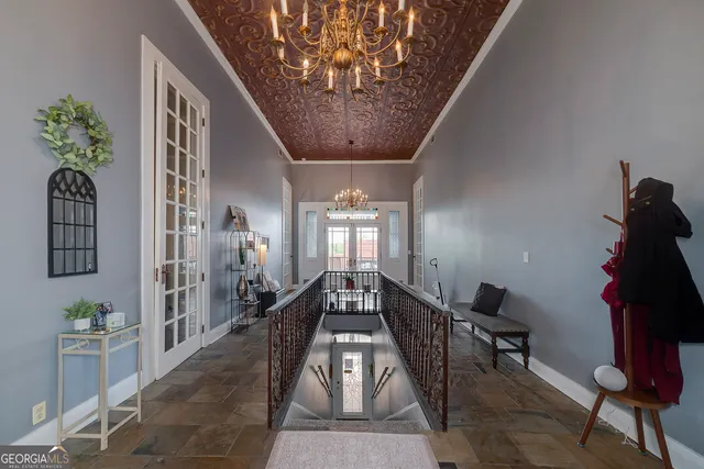 a lobby with furniture and chandelier