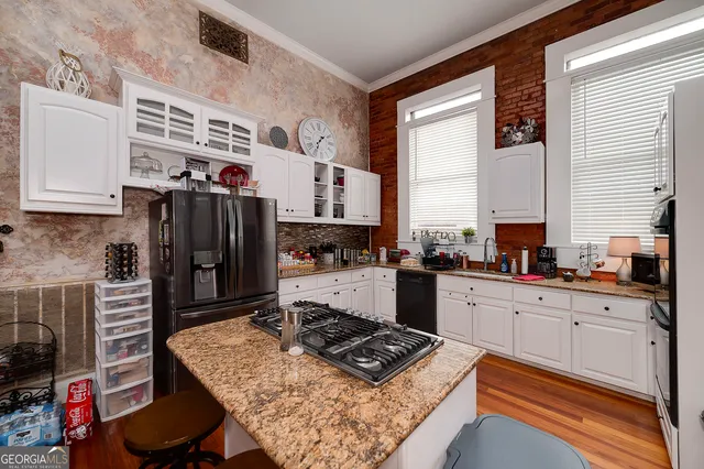 a kitchen with stainless steel appliances granite countertop a stove refrigerator sink and cabinets