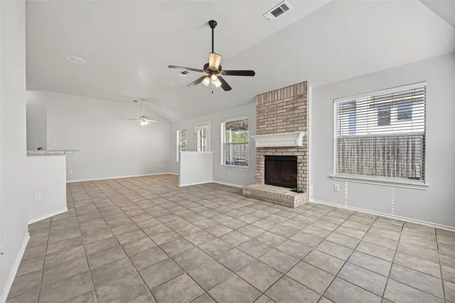 a view of an empty room with window and fireplace