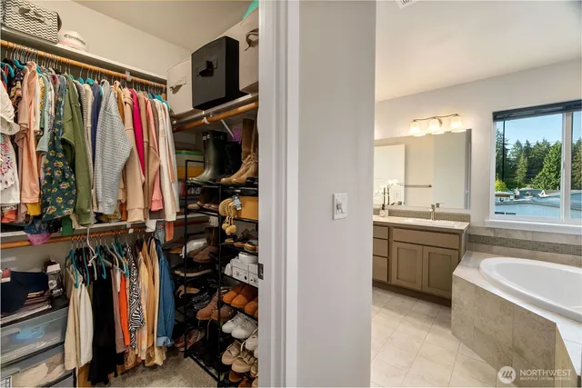a view of walk in closet with clothes and shoes