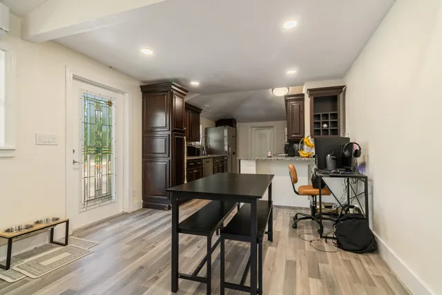 a kitchen with granite countertop stainless steel appliances a sink stove refrigerator and cabinets