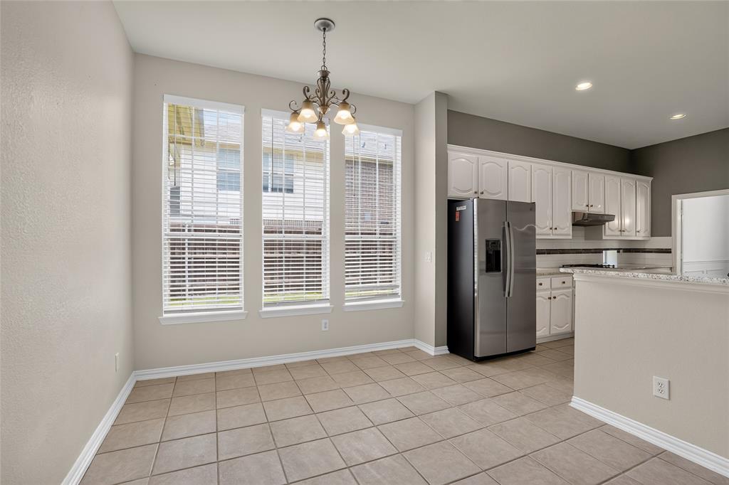 111 Ripplewood Coppell, TX 75019 - Photo 11 of 34 Dining area featuring three large windows with blinds, a chandelier, and tile flooring