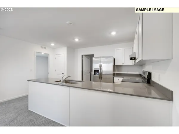 a kitchen with stainless steel appliances granite countertop a sink a stove and a refrigerator