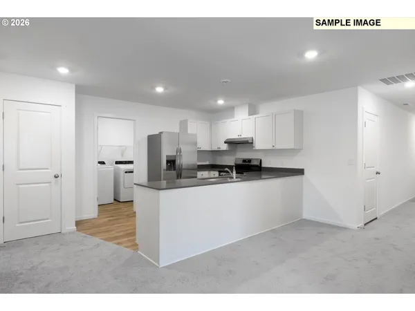 a kitchen with stainless steel appliances kitchen island sink refrigerator and microwave