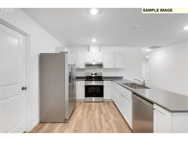a kitchen with stainless steel appliances a refrigerator sink and stove