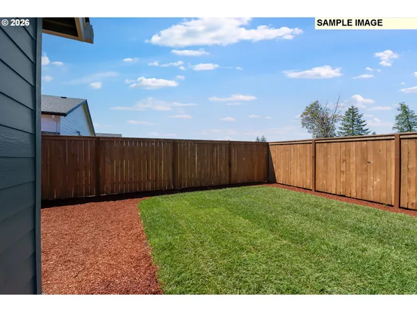 a view of backyard with wooden fence