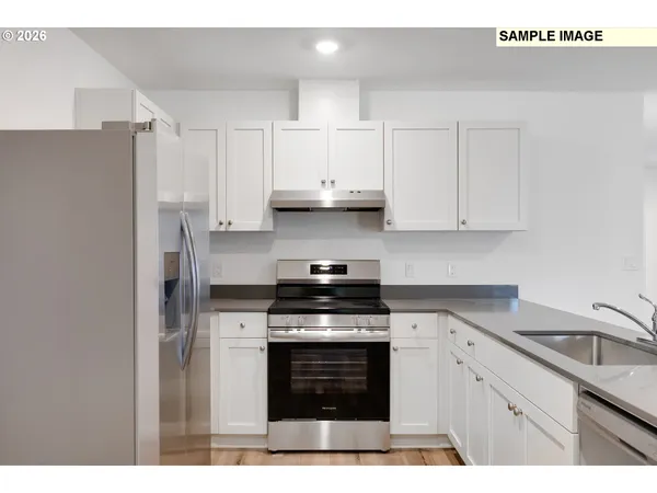 a kitchen with stainless steel appliances granite countertop a stove a sink and a refrigerator