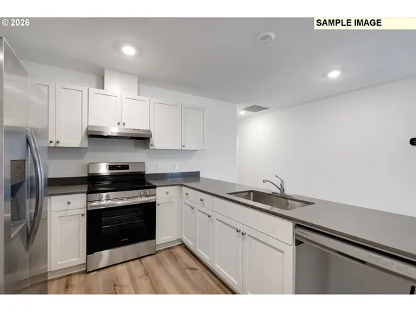 a kitchen with stainless steel appliances granite countertop a sink stove and white cabinets