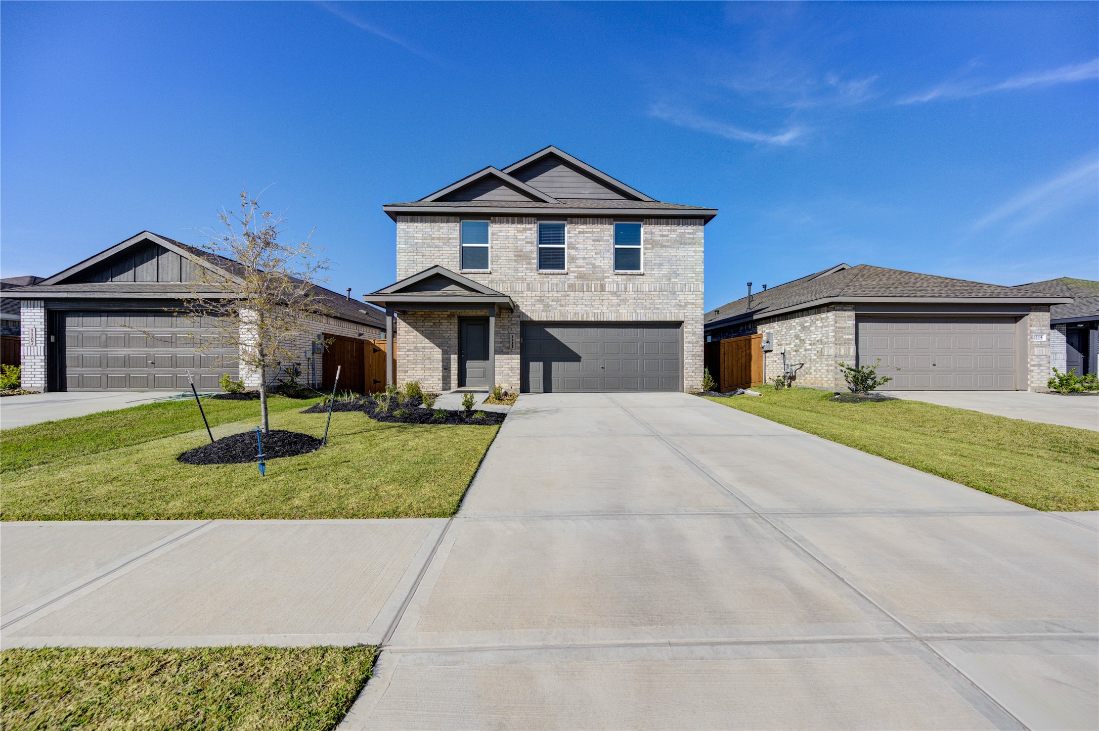 1111 Rustic Willow Drive Beasley, TX 77417 - Photo 1 of 42 Modern two-story brick home with a double garage, set in a suburban neighborhood. The driveway is spacious, and the front yard features minimal landscaping with trees and shrubs. The house has a clean, contemporary design with a neutral color palette.