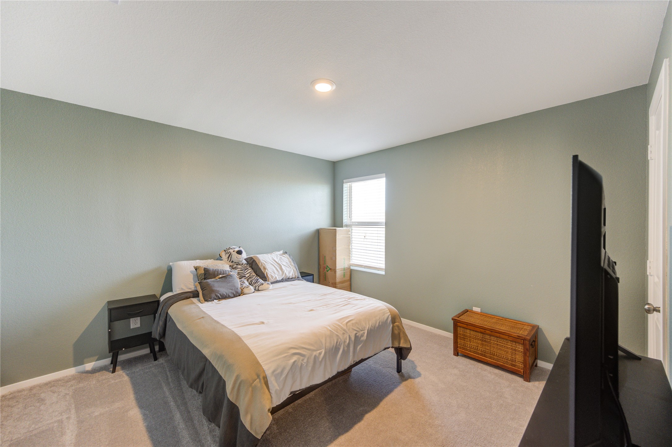 1111 Rustic Willow Drive Beasley, TX 77417 - Photo 25 of 42 This bedroom features a comfortable layout with soft carpeting, a bed with neutral bedding, and a window providing natural light. The walls are painted a calming shade, and there's ample space for additional furniture.