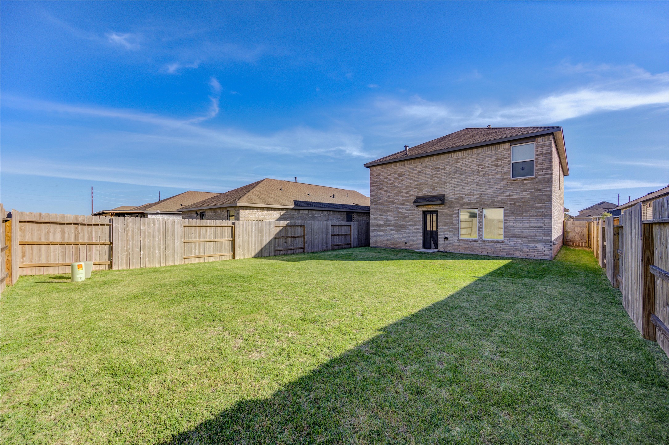 1111 Rustic Willow Drive Beasley, TX 77417 - Photo 33 of 42 Spacious fenced backyard with well-maintained lawn, perfect for outdoor activities. The brick home offers privacy and ample natural light.