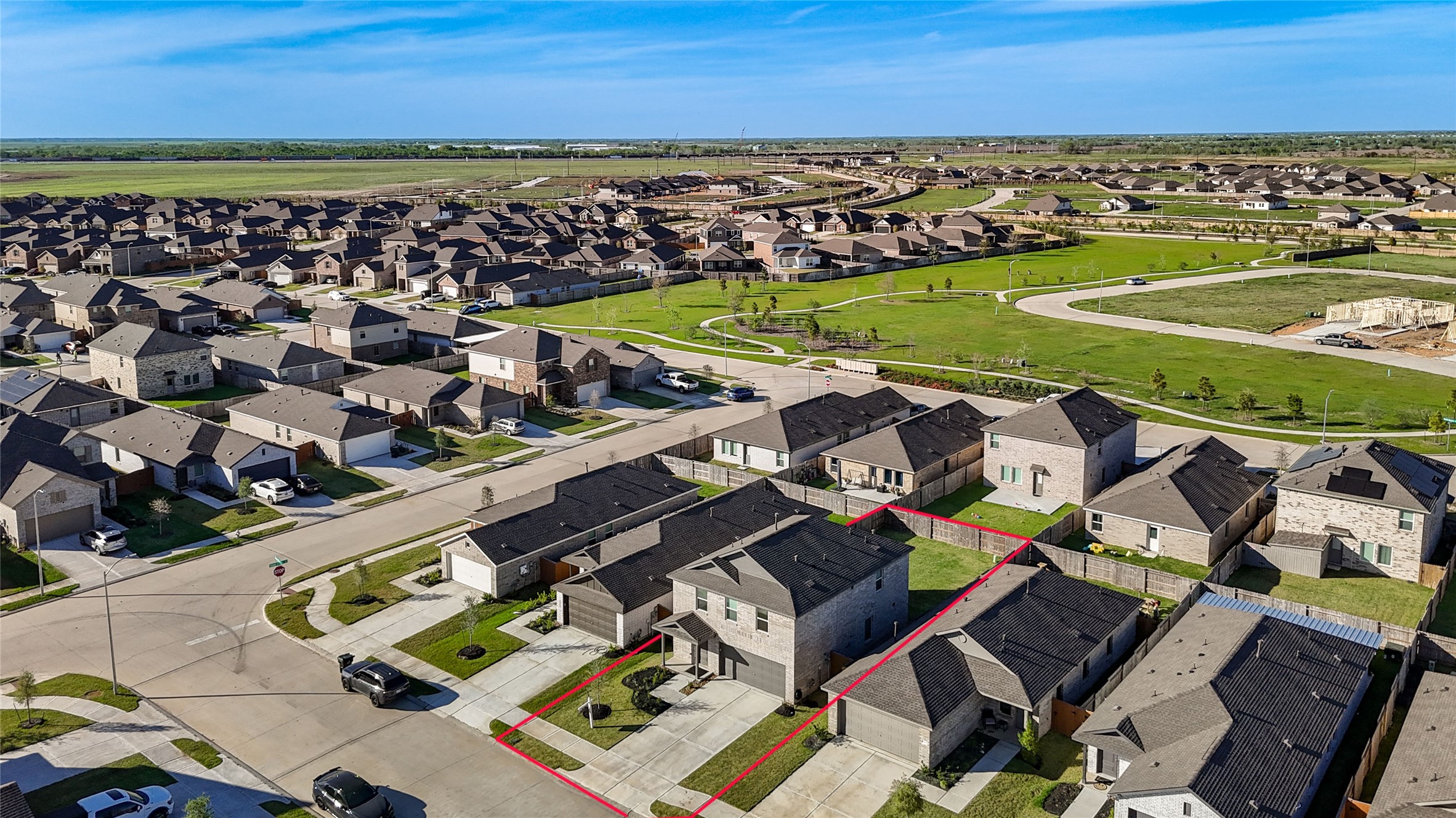 1111 Rustic Willow Drive Beasley, TX 77417 - Photo 41 of 42 This aerial photo showcases a modern suburban neighborhood with neatly arranged homes, highlighting a specific two-story house marked by red boundary lines. The area features well-maintained lawns, wide streets, and nearby green spaces, offering a spacious and inviting residential environment.