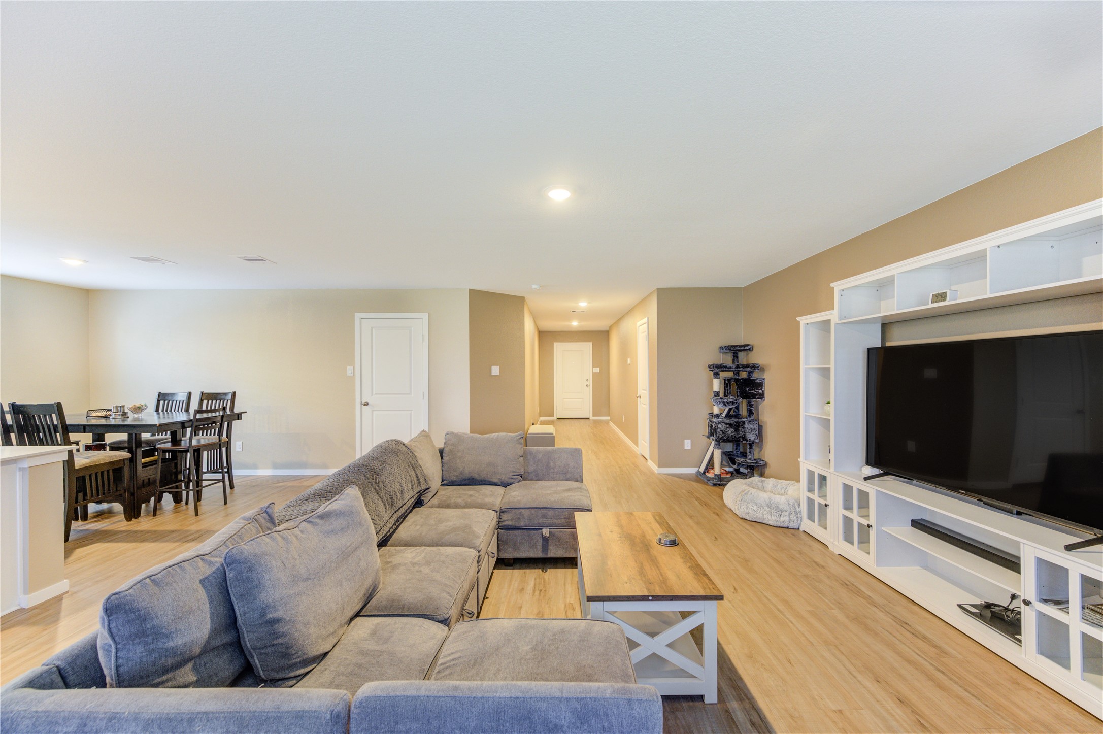 1111 Rustic Willow Drive Beasley, TX 77417 - Photo 42 of 42 This spacious living area features an open floor plan with light wood flooring, a cozy sectional sofa, a large entertainment center, and a dining area. Ideal for entertaining and family gatherings.