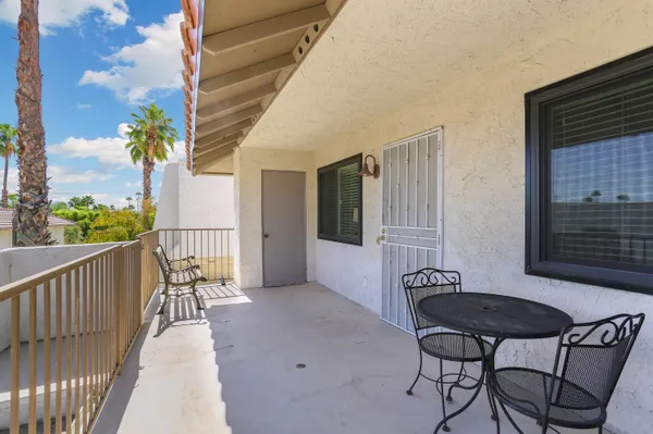 a balcony with table and chairs