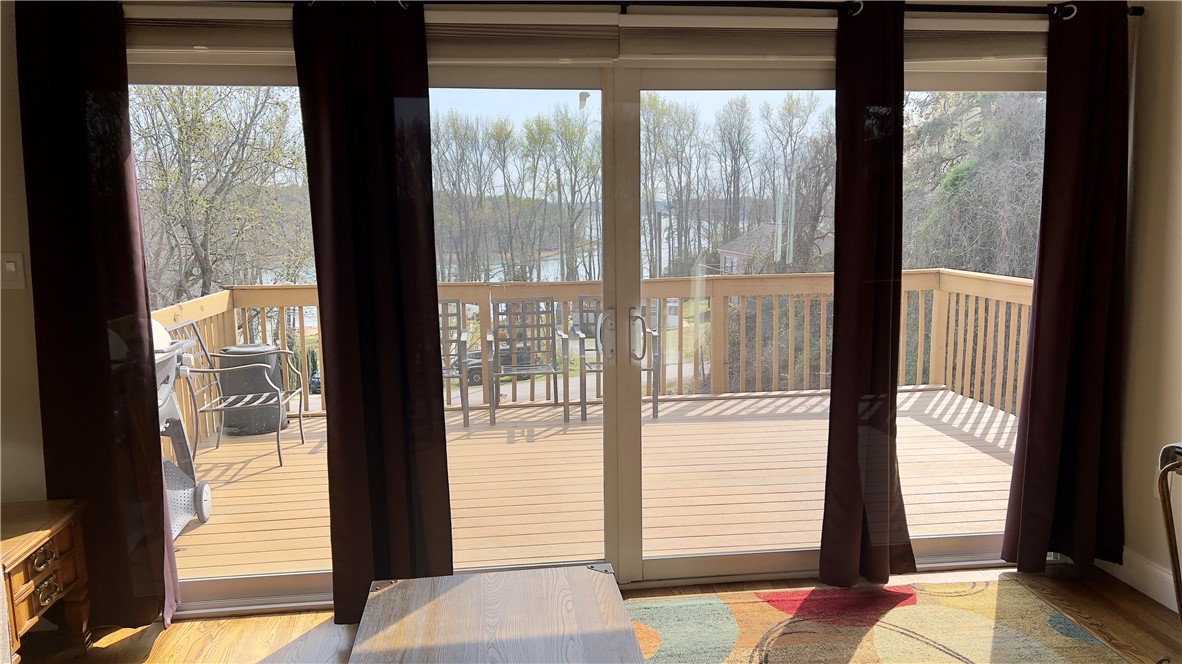 160 Hudgins Lake Road Townville, SC 29689 - Photo 29 of 41 Sliding glass doors open onto a spacious wooden deck with scenic water views.