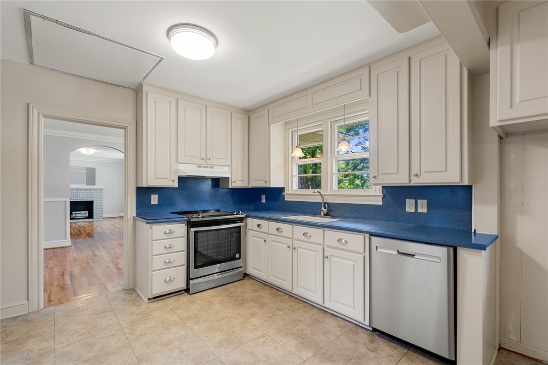 1509 869 Anderson, SC 29621 - Photo 14 of 45 A well-equipped kitchen features white cabinetry and bright blue countertops with a view of green foliage.