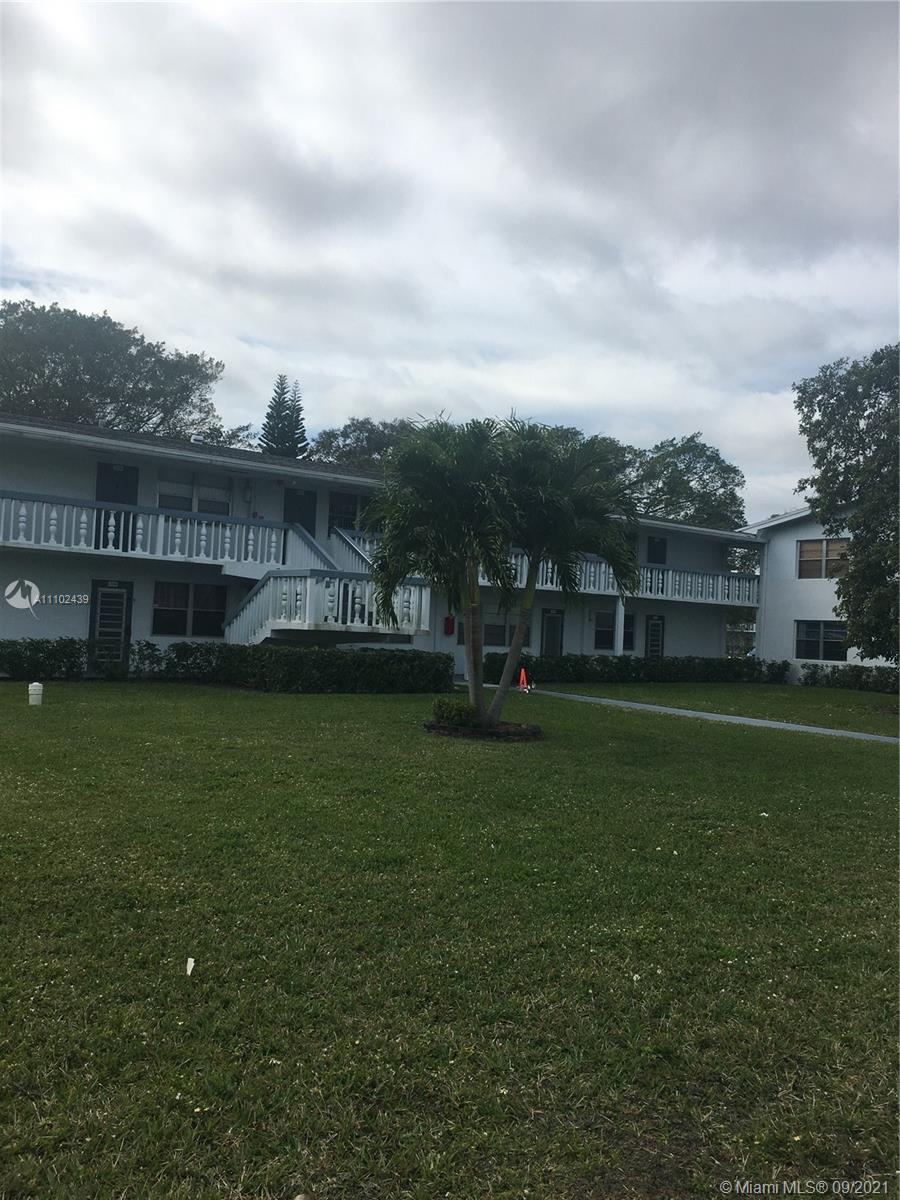 331 Farnham P, Unit 331 Deerfield Beach, FL 33442 - Photo 11 of 11 a view of a garden with a bench in the background