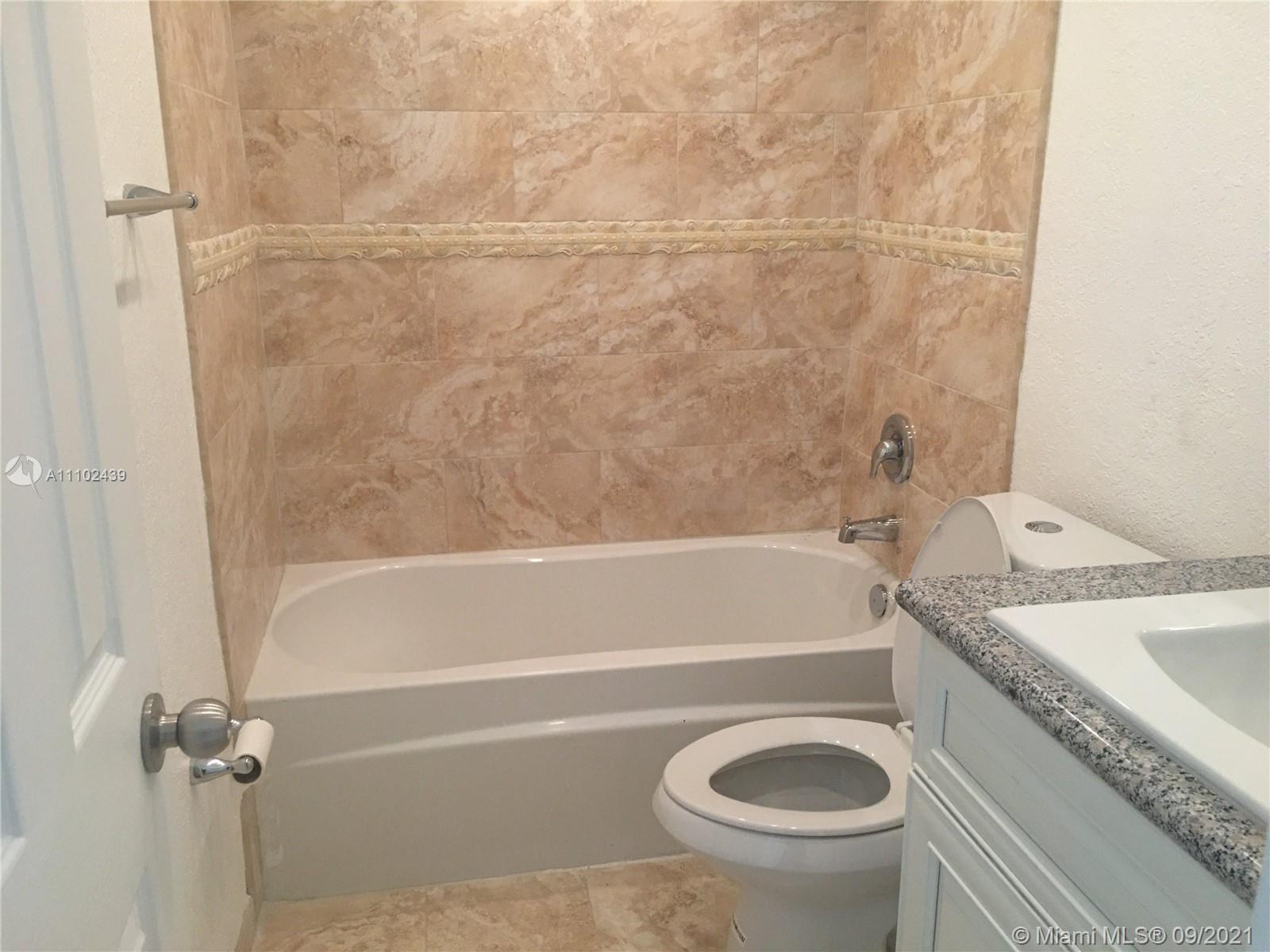 331 Farnham P, Unit 331 Deerfield Beach, FL 33442 - Photo 4 of 11 a bathroom with a granite countertop bathtub sink vanity mirror and toilet