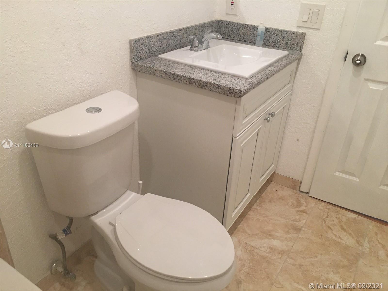 331 Farnham P, Unit 331 Deerfield Beach, FL 33442 - Photo 5 of 11 a bathroom with a sink a toilet and mirror