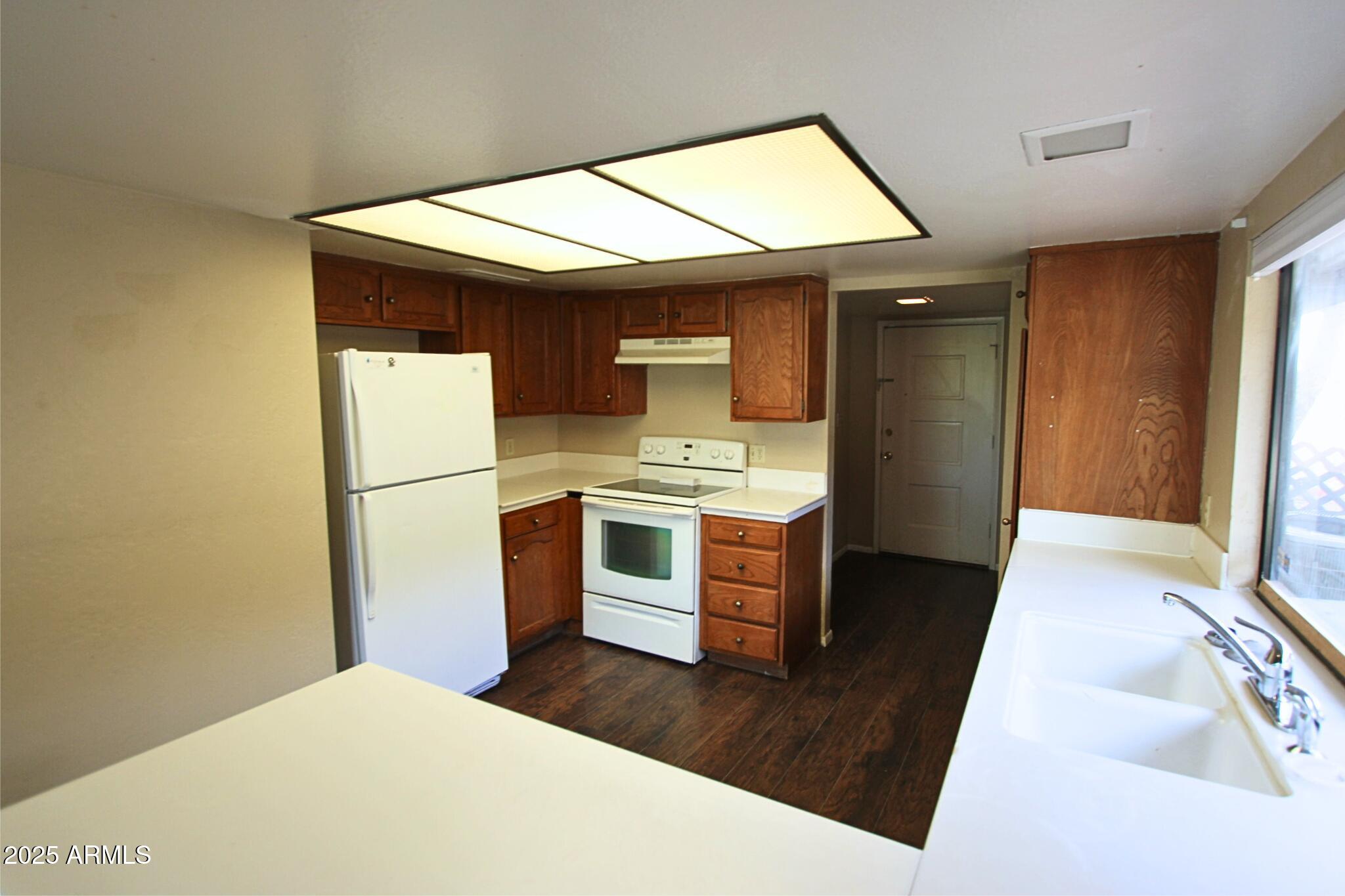 824 East Junction Street Apache Junction, AZ 85119 - Photo 5 of 9 a kitchen with a refrigerator and a stove top oven