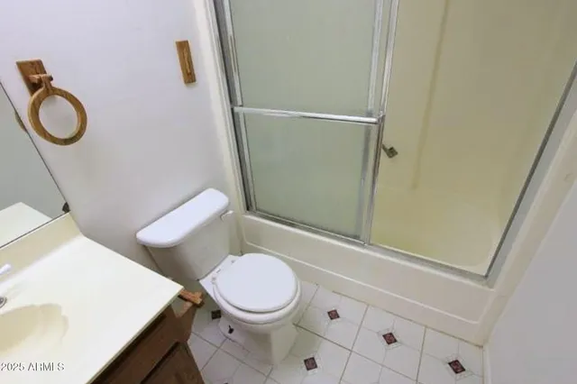 a white toilet sitting next to a bathroom sink and vanity