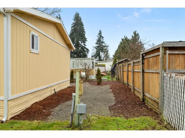 a view of a house with backyard and trees
