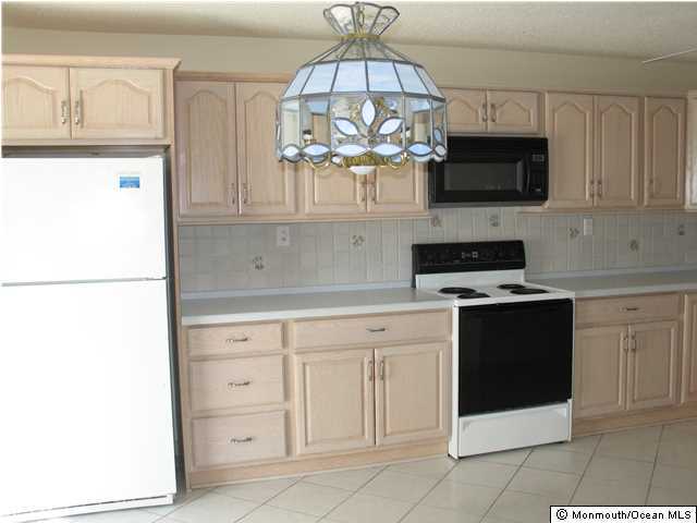 95 Halls Croft Road, Unit A Freehold, NJ 07728 - Photo 2 of 15 a kitchen with stainless steel appliances white cabinets and a sink