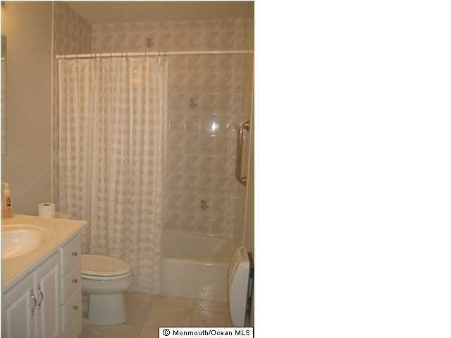 95 Halls Croft Road, Unit A Freehold, NJ 07728 - Photo 6 of 15 a bathroom with a shower curtain and a sink